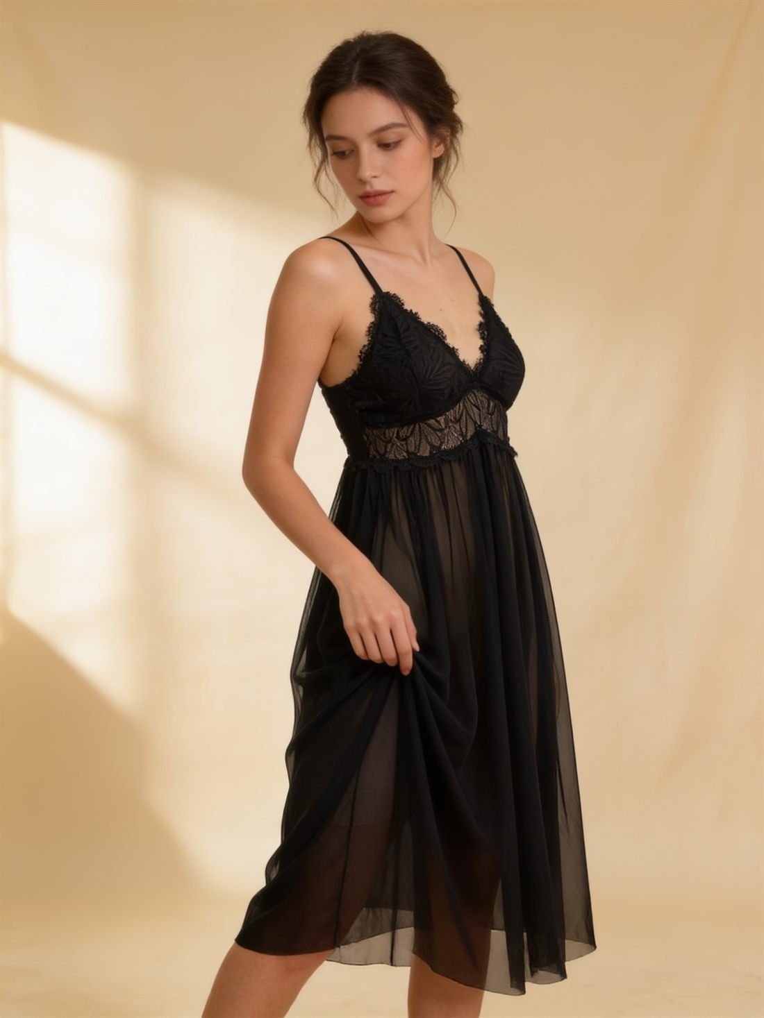 Manken üzerinde, sıcak fildişi zeminde üç çeyrek duruş — Siyah dantel şeffaf babydoll; çiçek desenli Fransız danteli korsaj ve dökümlü şeffaf tül etek. Diamels premium iç giyim.