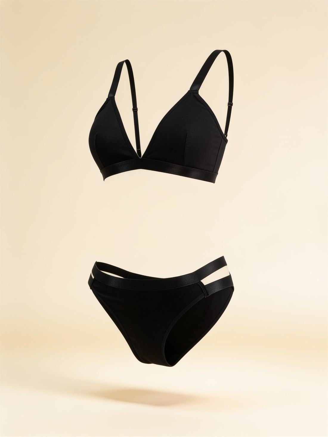 Ürün tek başına, hayalet manken tekniğiyle havada dururken — Siyah üçgen bralet takım; dolgusuz üçgen bralet ve yan çift saten şeritli külot. Diamels premium iç giyim.