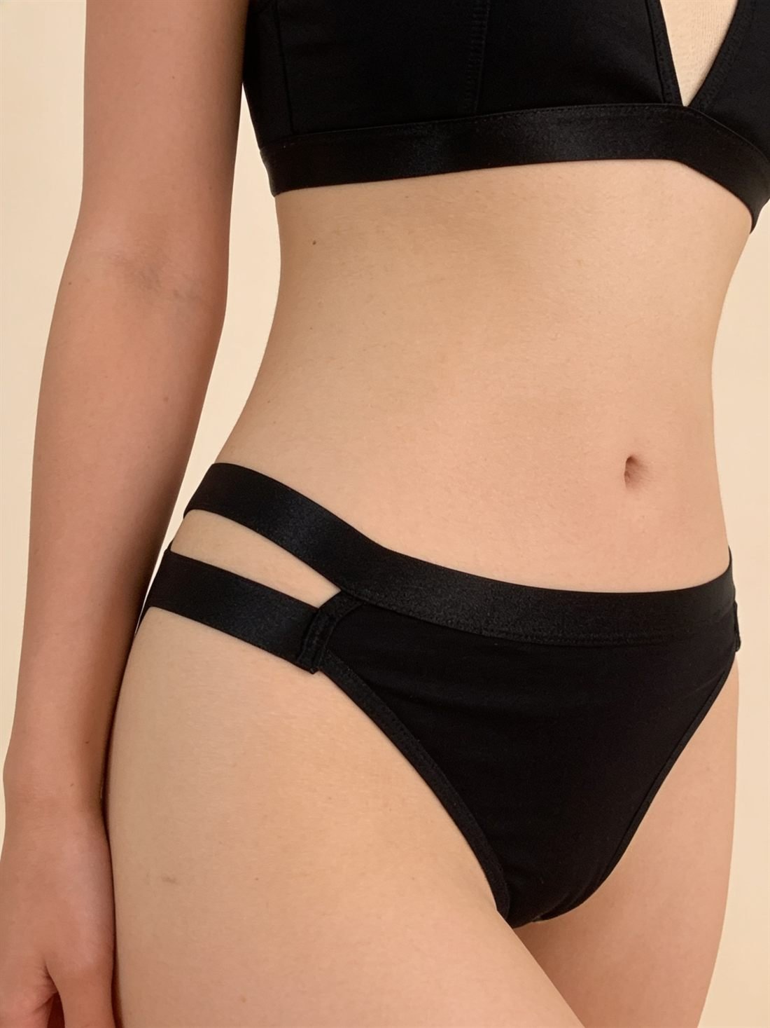Yakın plan detay; dokunun, dikişin ve işçiliğin makro görünümü — Siyah üçgen bralet takım; dolgusuz üçgen bralet ve yan çift saten şeritli külot. Diamels premium iç giyim.